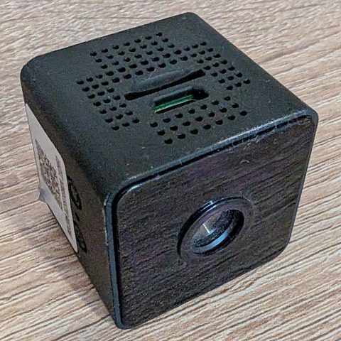 Mini WiFi cube camera from the side, with the QR sticker, MODE button and microSD slot